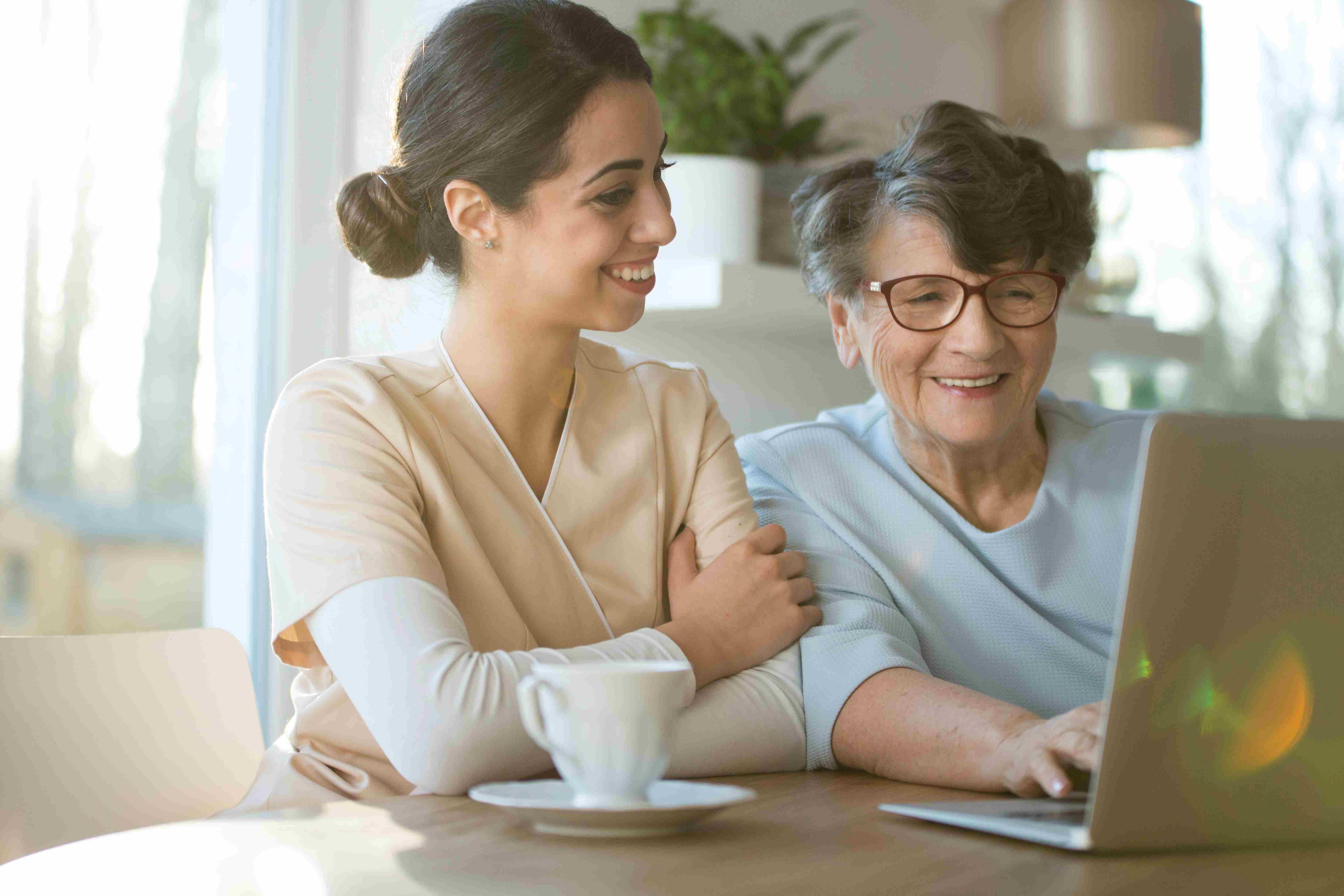 two ladies laughing in front of screen